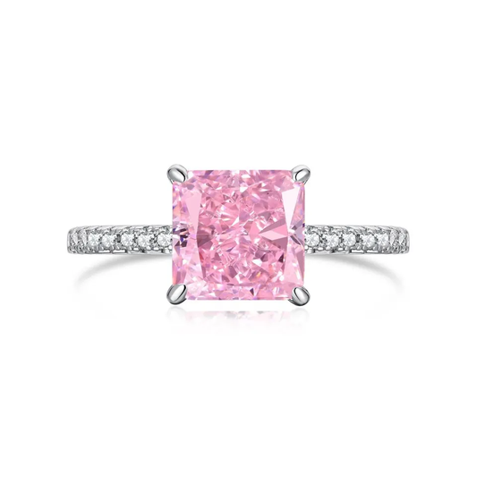 925 silver, rhodium-plated ring with hand-inlaid zirkonia on the band and a large, rosy-colored, cube-shaped zirkonia in the centre. 